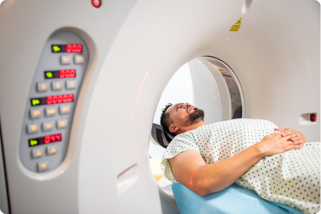 Homem deitado em aparelho de diagnóstico por imagem com luzes de alinhamento a laser.